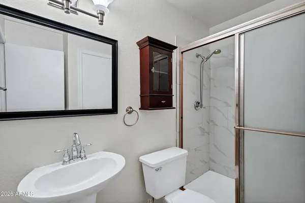 an empty room with chandelier fan and windows
