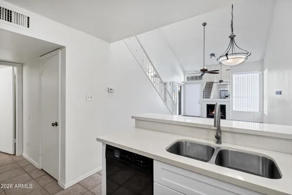 a view of a big room with chandelier fan and windows