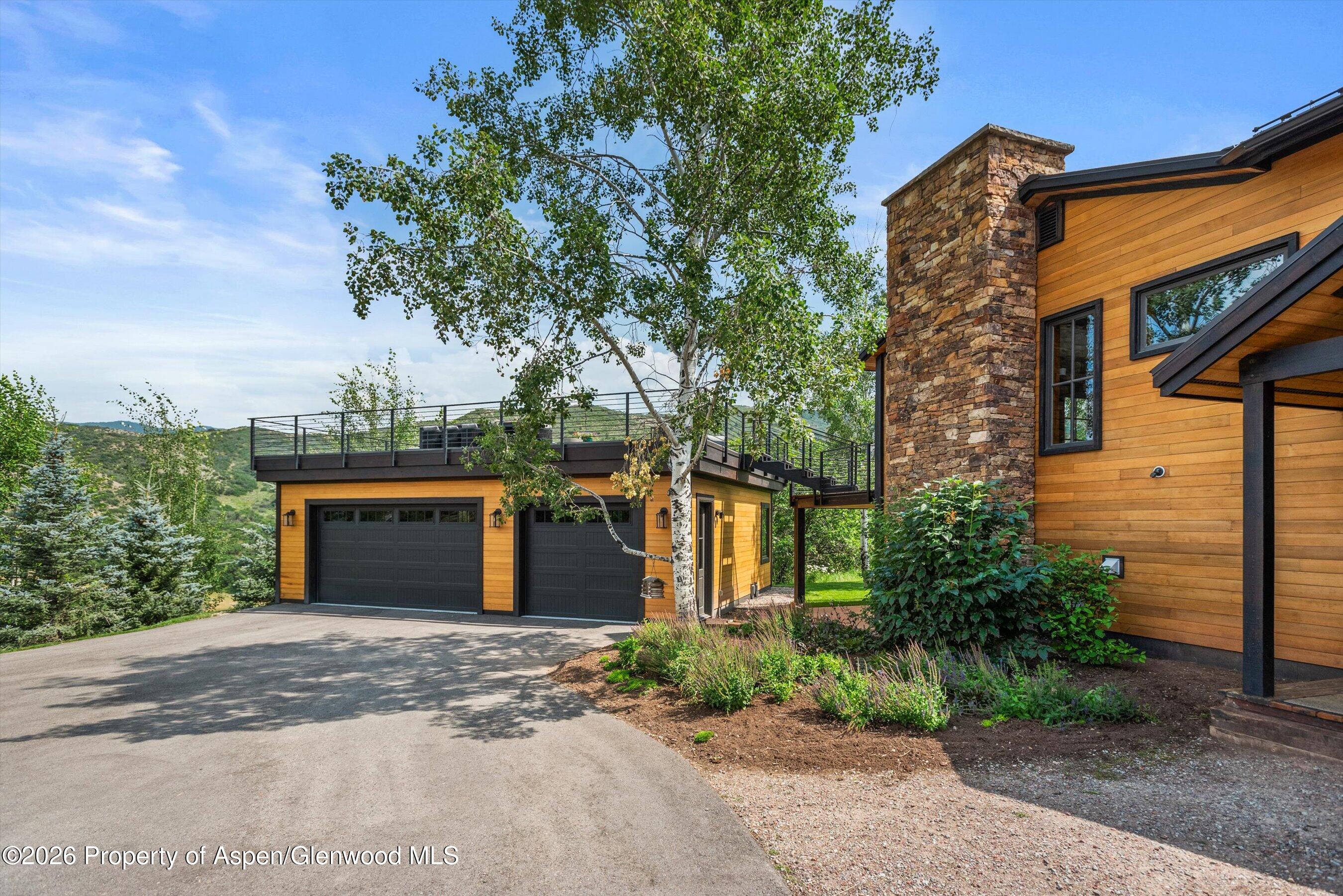 701 Brush Creek Road Aspen, CO 81611 - Photo 6 of 18 a view of a house with a yard and potted plants
