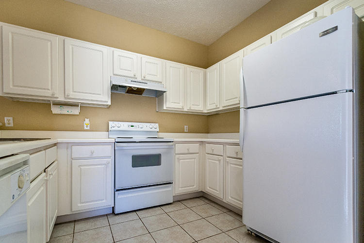 34 Heron's Watch Way, Unit 1304 Santa Rosa Beach, FL 32459 - Photo 6 of 15 a kitchen with white cabinets and white appliances