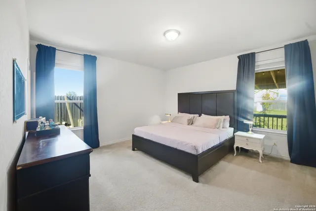 a spacious bedroom with a bed lamp and a large window