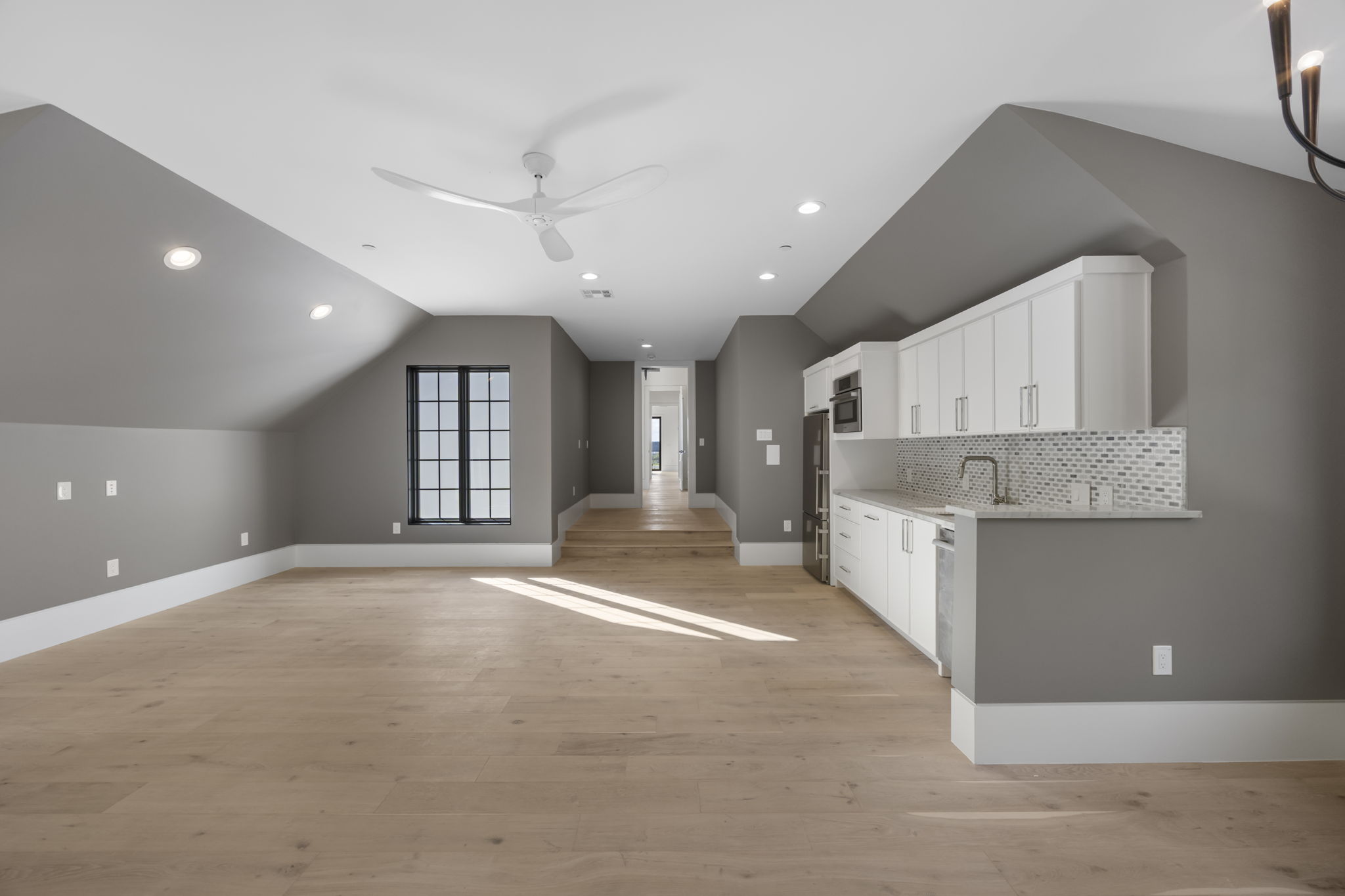 1496 Buffalo Gap Road Lakeway, TX 78734 - Photo 27 of 37 A grand entertainment room with soaring vaulted ceilings, recessed lighting, and a modern kitchen space.