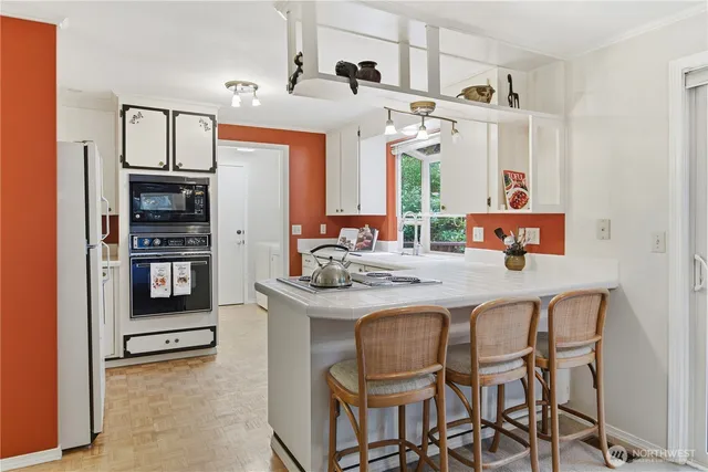 a kitchen with white cabinets and window