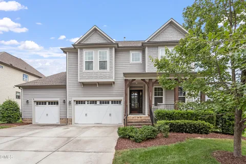 a front view of a house with a garden and garage