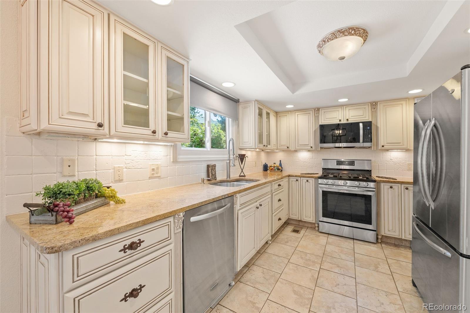 9368 Harvard Drive Highlands Ranch, CO 80130 - Photo 12 of 46 a kitchen with granite countertop a sink stainless steel appliances and cabinets