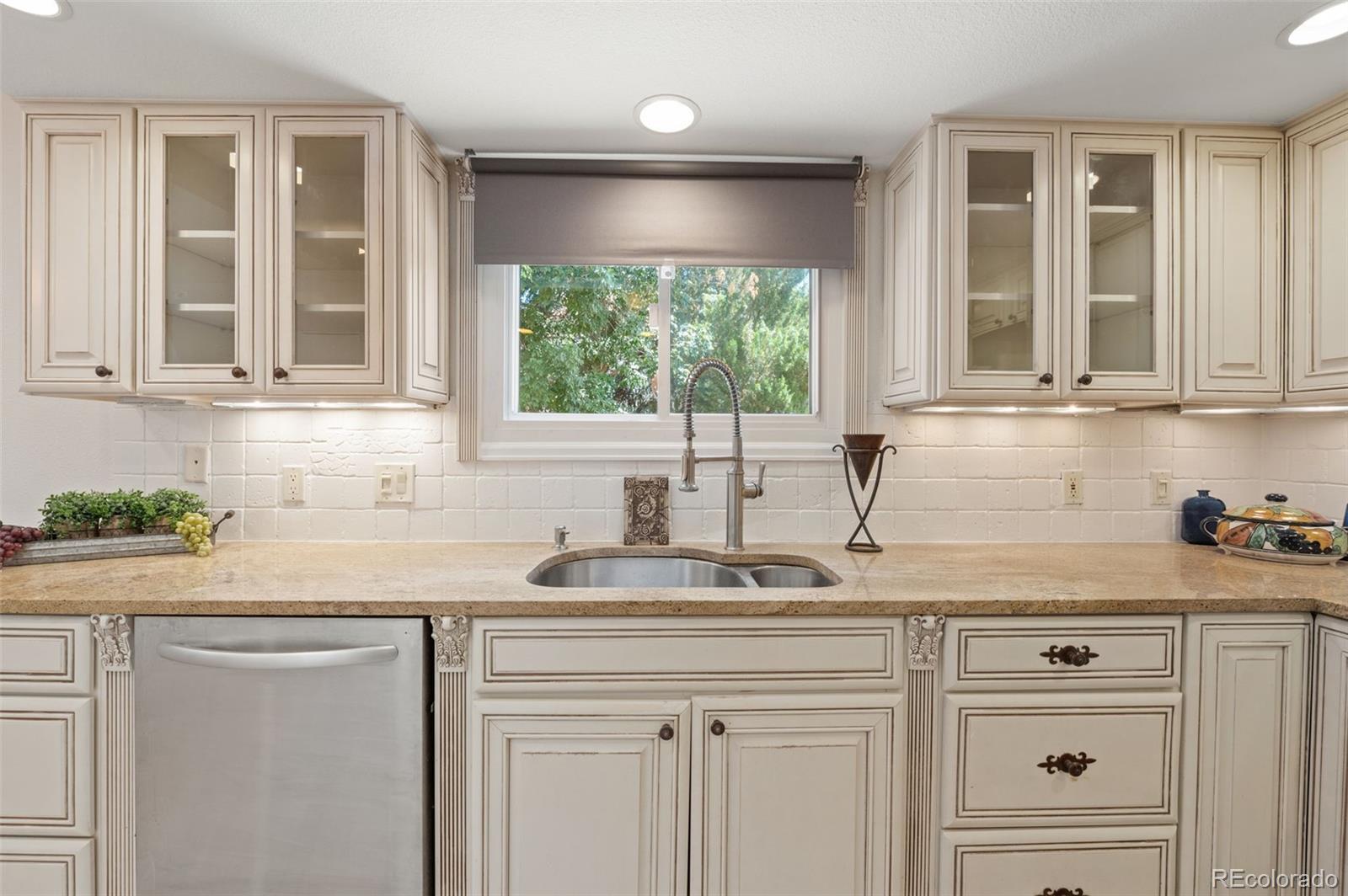 9368 Harvard Drive Highlands Ranch, CO 80130 - Photo 13 of 46 a kitchen with stainless steel appliances granite countertop a sink a stove and cabinets