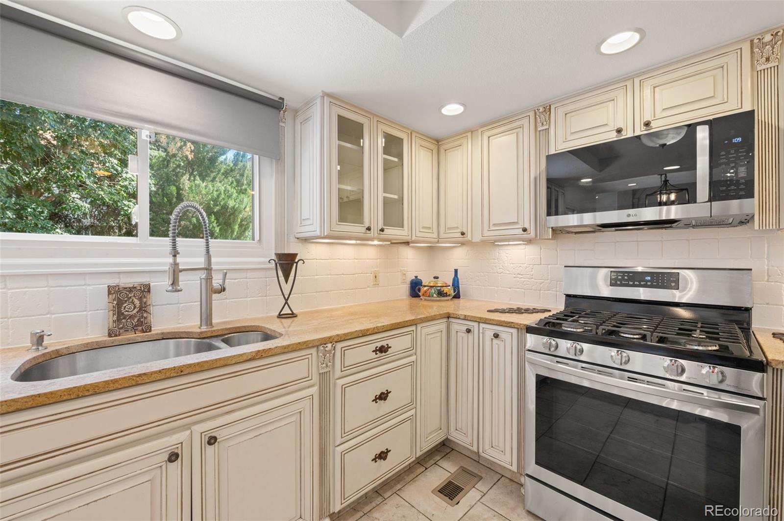 9368 Harvard Drive Highlands Ranch, CO 80130 - Photo 14 of 46 a kitchen with granite countertop white cabinets stainless steel appliances and a sink