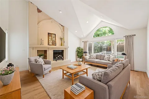a living room with furniture a large window and a fireplace