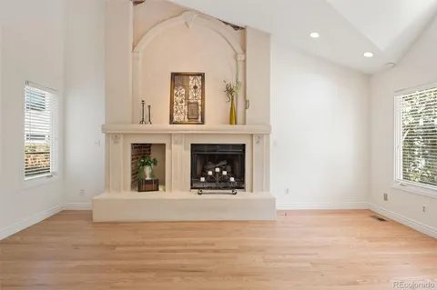a view of an empty room with a window and fireplace