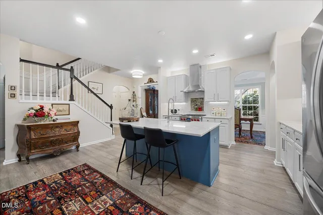 a kitchen with stainless steel appliances granite countertop a stove top oven a sink dishwasher and cabinets with wooden floor