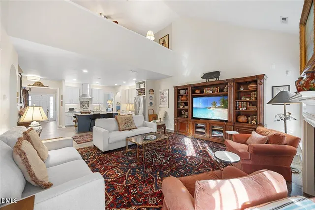 a spacious bedroom with a bed a chandelier and a dresser
