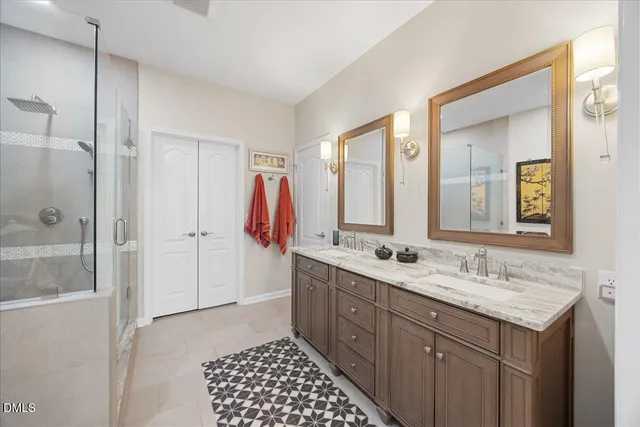 a kitchen that has a lot of white cabinets and stainless steel appliances