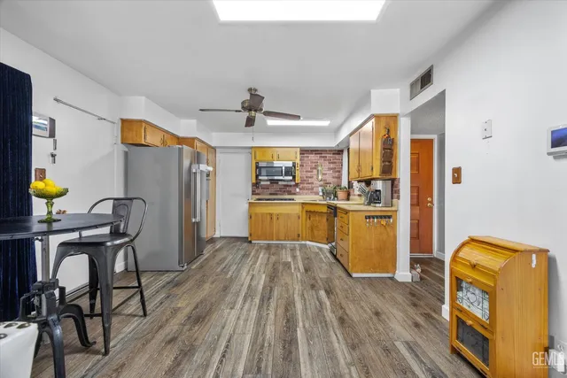 a kitchen with stainless steel appliances granite countertop a sink and wooden floors