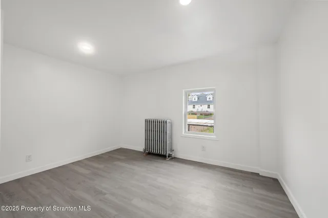 a view of a room with wooden floor