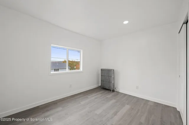 a view of a hallway with wooden floor and entryway
