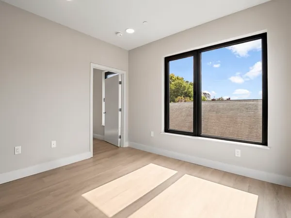 a view of an empty room with a window and a floor to ceiling window