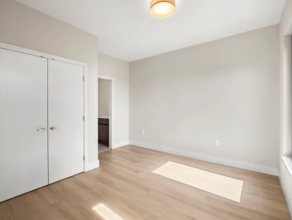 a view of an empty room with wooden floor