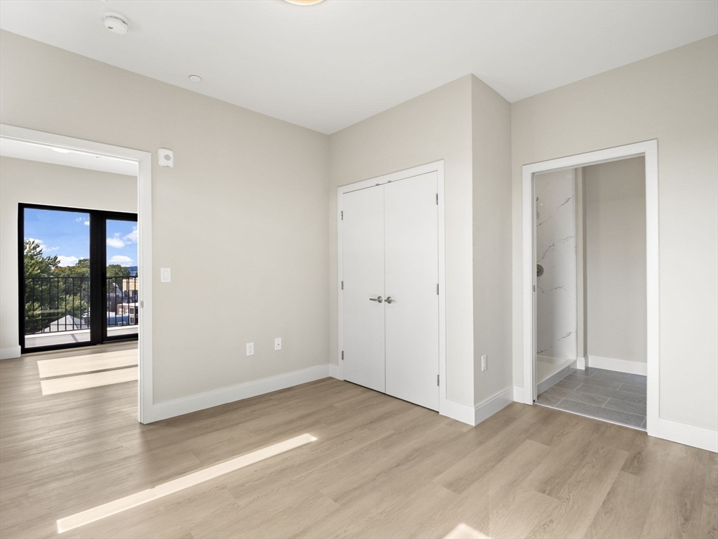 249 Corey Road, Unit 401 Boston, MA 02135 - Photo 16 of 34 an empty room with wooden floor and windows