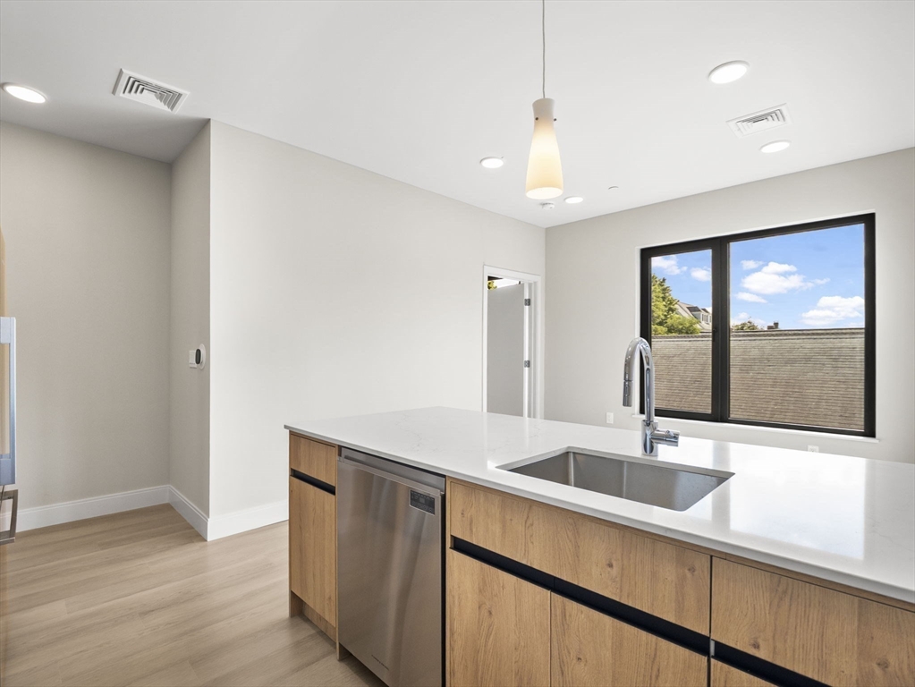 249 Corey Road, Unit 401 Boston, MA 02135 - Photo 2 of 34 a hallway with sink and mirror