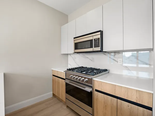 a kitchen with granite countertop cabinets stainless steel appliances and wooden floor