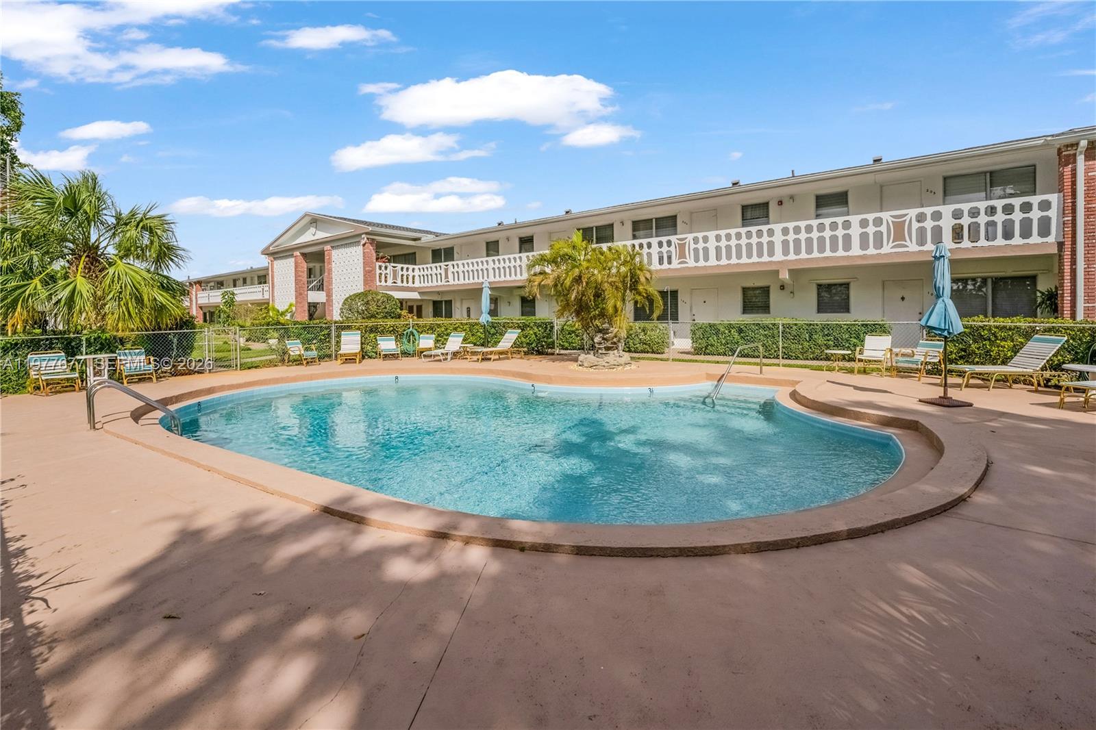 3701 Tyler Street, Unit 211 Hollywood, FL 33021 - Photo 1 of 26 a view of a white building with a swimming pool
