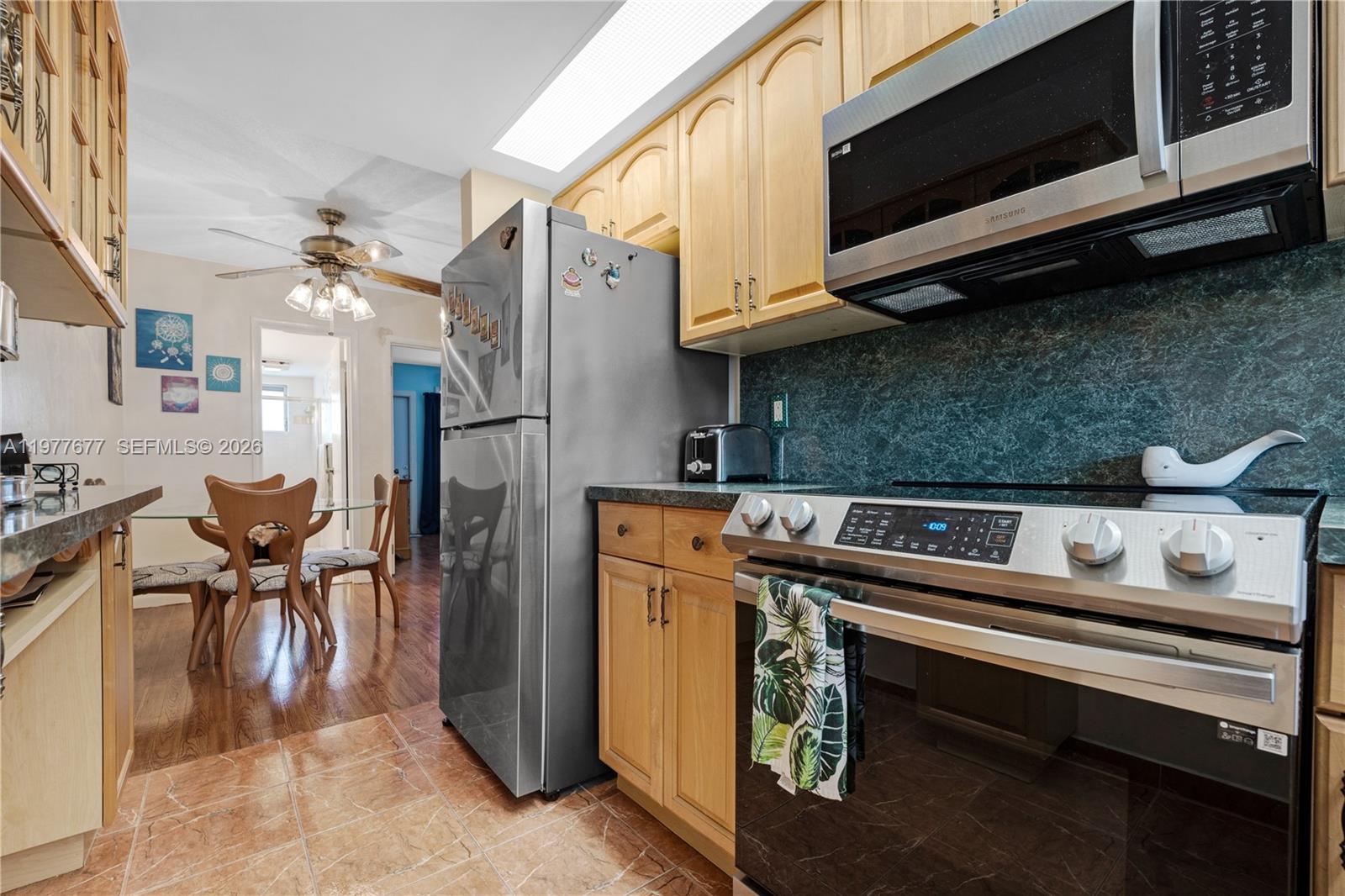 3701 Tyler Street, Unit 211 Hollywood, FL 33021 - Photo 11 of 26 a kitchen with stainless steel appliances kitchen island granite countertop a refrigerator stove and microwave