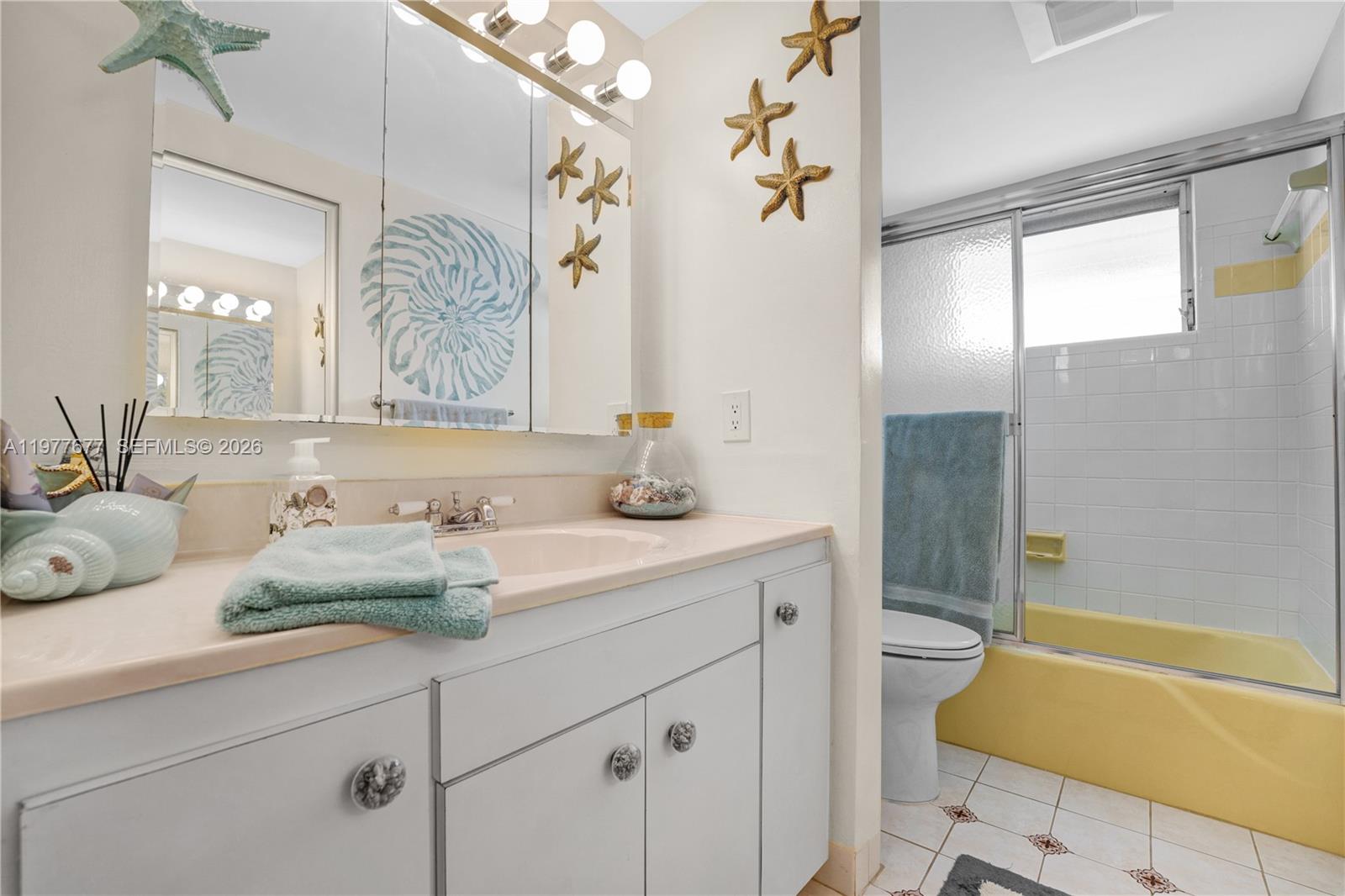 3701 Tyler Street, Unit 211 Hollywood, FL 33021 - Photo 17 of 26 a bathroom with a sink and a mirror with bathtub