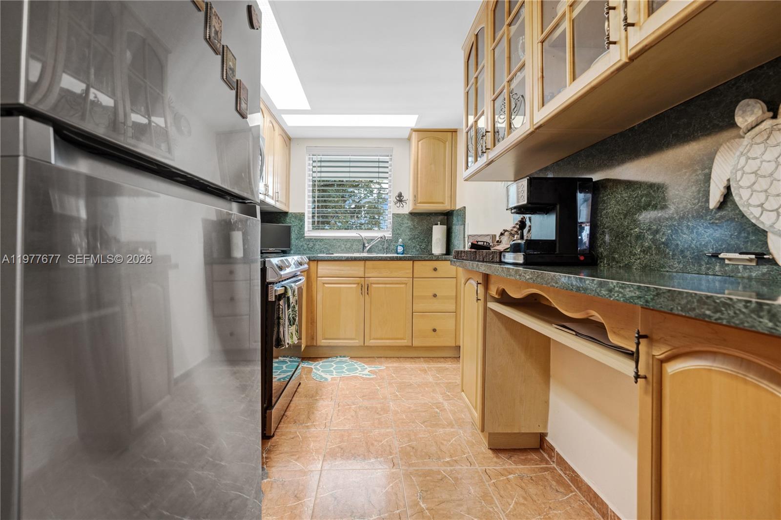 3701 Tyler Street, Unit 211 Hollywood, FL 33021 - Photo 9 of 26 a kitchen with stainless steel appliances granite countertop a sink a stove and a refrigerator