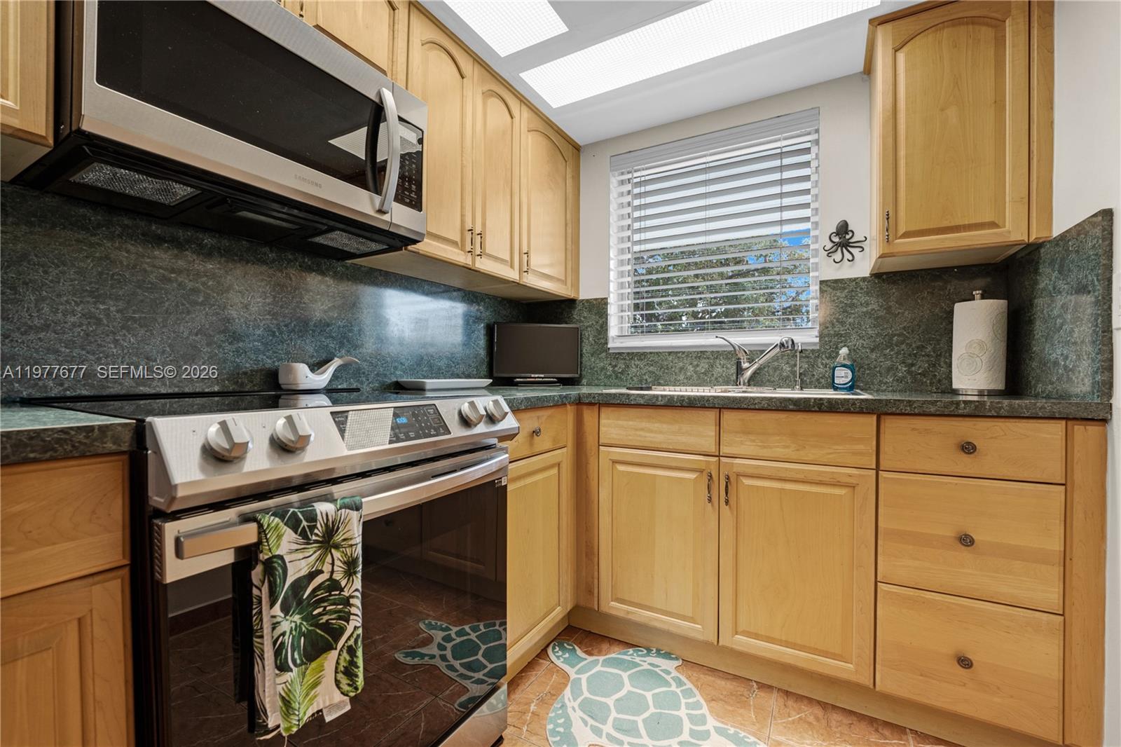 3701 Tyler Street, Unit 211 Hollywood, FL 33021 - Photo 10 of 26 a kitchen with stainless steel appliances granite countertop a sink a stove and a microwave
