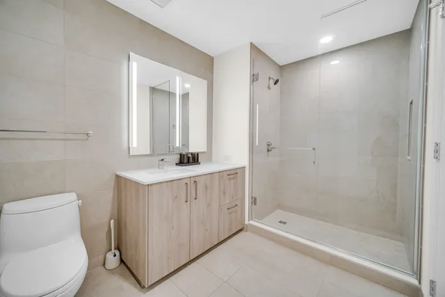 a bathroom with a double vanity sink toilet and shower