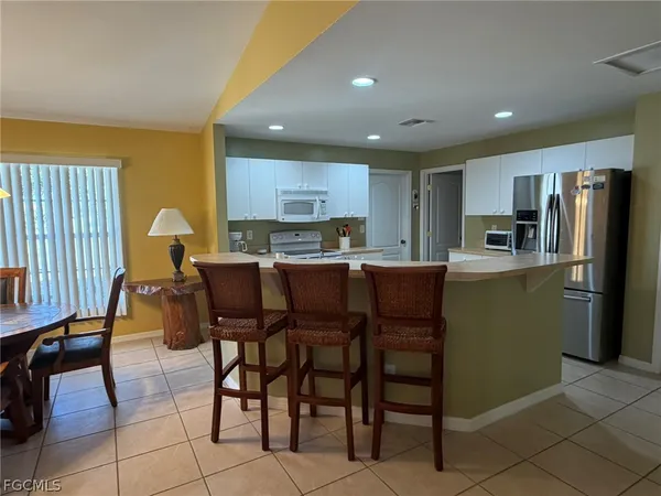 a kitchen with stainless steel appliances granite countertop a table and chairs