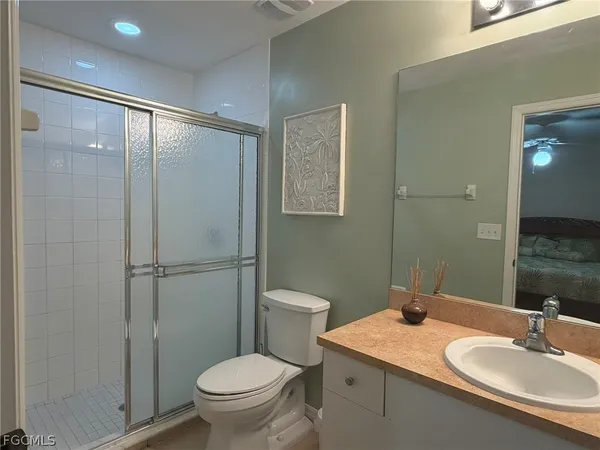 a bathroom with a granite countertop sink toilet and shower