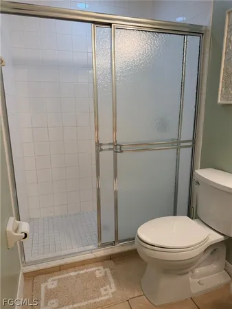 a white toilet sitting next to a shower