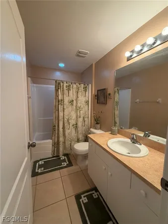 a bathroom with a granite countertop sink a toilet a mirror and shower