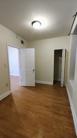 an empty room with closet and wooden floor