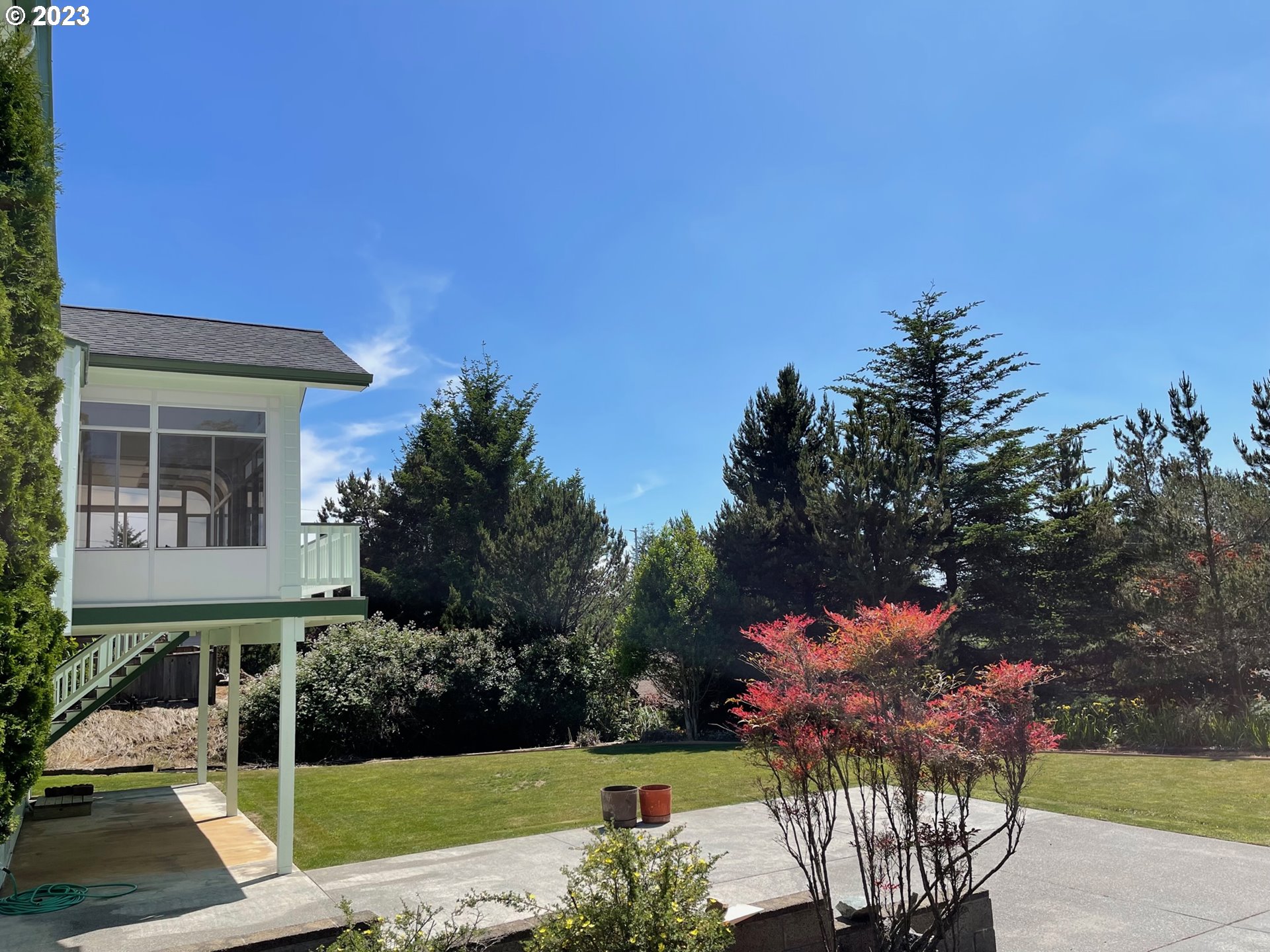 919 3rd Street Brookings, OR 97415 - Photo 4 of 36 a front view of a house with a yard fountain and a fire pit