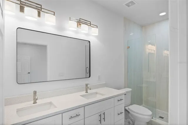 a bathroom with a toilet a sink a mirror and vanity