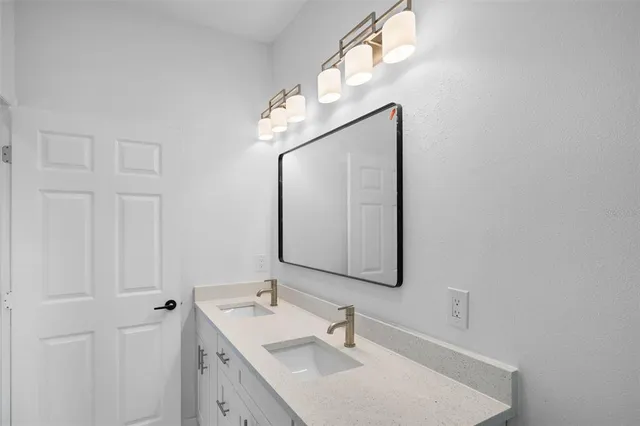 a bathroom with a sink vanity and mirror