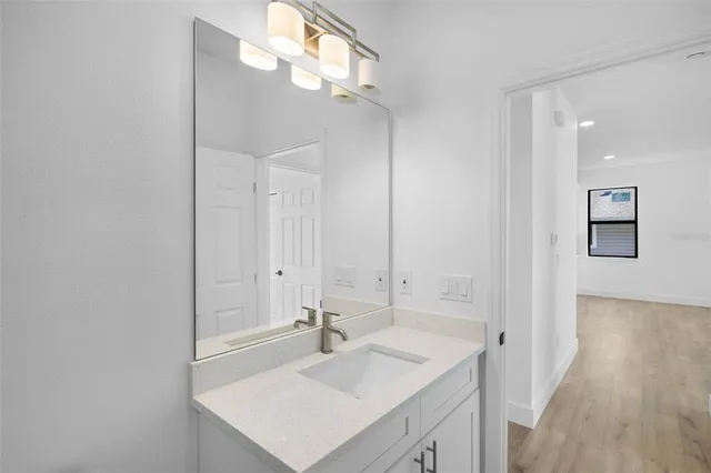 a bathroom with a sink a light fixture and a mirror
