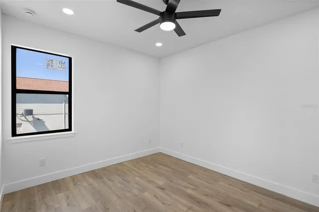 an empty room with a window and a ceiling fan
