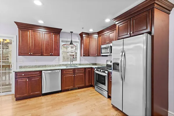 a kitchen with stainless steel appliances granite countertop a refrigerator and a stove top oven