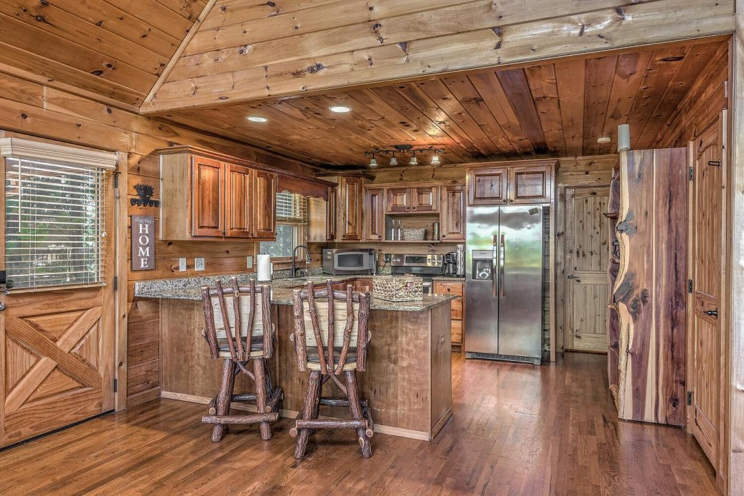 398 Pin Oak Road Murphy, NC 28906 - Photo 13 of 30 a view of a kitchen with stainless steel appliances granite countertop a table chairs refrigerator and wooden floor