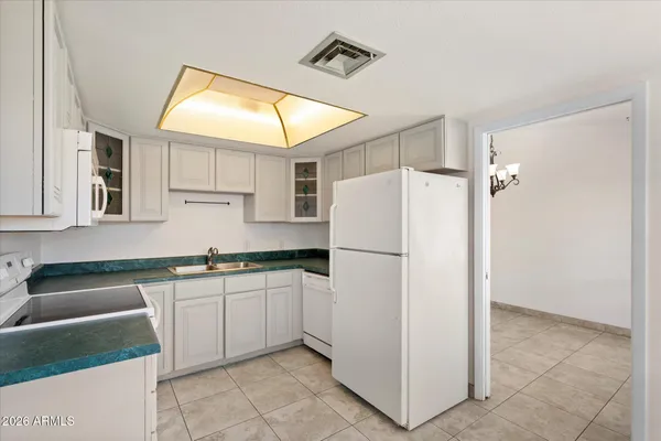 a kitchen with white cabinets and white appliances