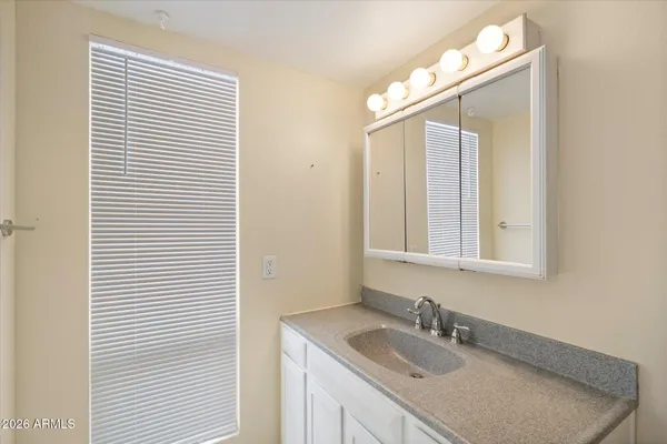 a bathroom with a granite countertop sink and a mirror