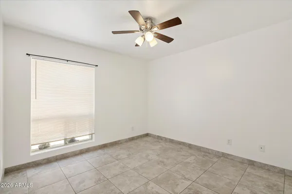 an empty room with a ceiling fan and window