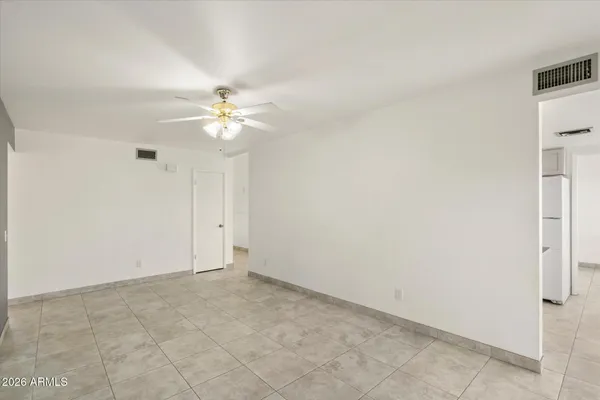 an empty room with windows and ceiling fan