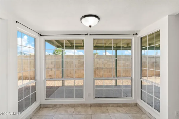 a view of an empty room with wooden floor and windows