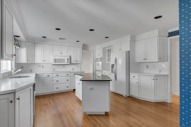 a kitchen with white cabinets and stainless steel appliances