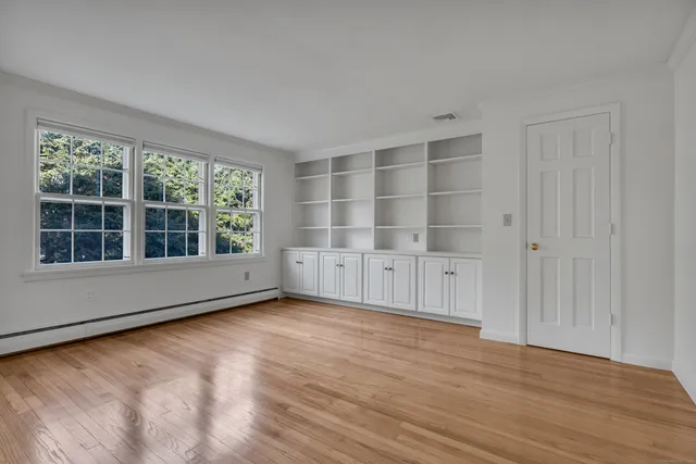 wooden floor in an empty room with a window