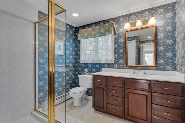 a bathroom with a double vanity sink mirror and toilet